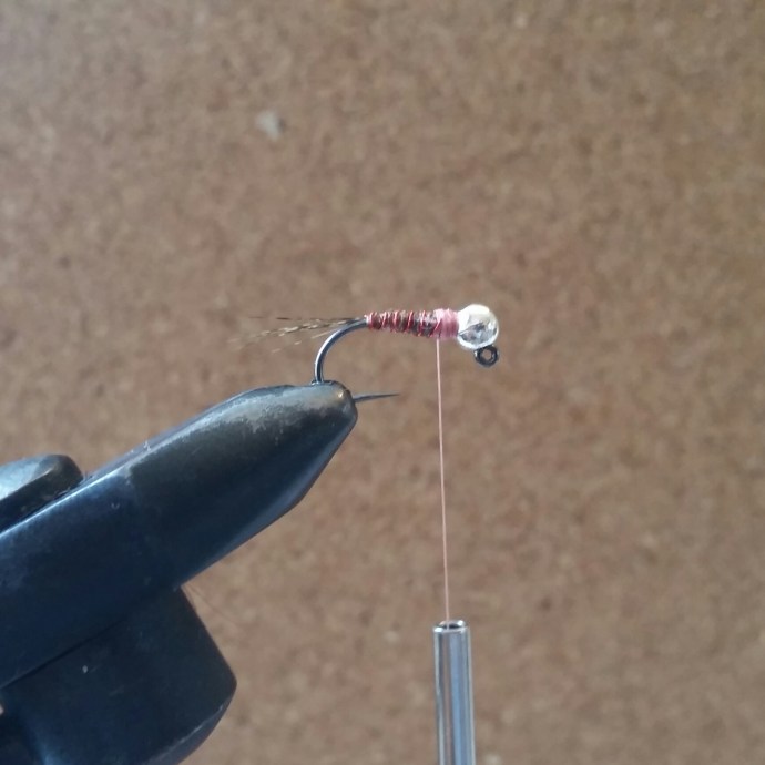 Switch back to your thread. Tie in tightly over the thorax of the fly. Tie the wire rib in turns matching those you just made with the Nymph-It and secure with your thread.